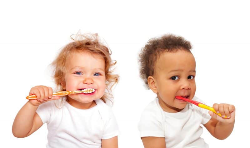 دو کودک در حال مسواک کردن دندان
