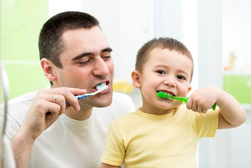کودک و پدر در حال نظافت دندان