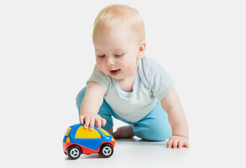 کودک در حال بازی با ماشین اسباب بازی