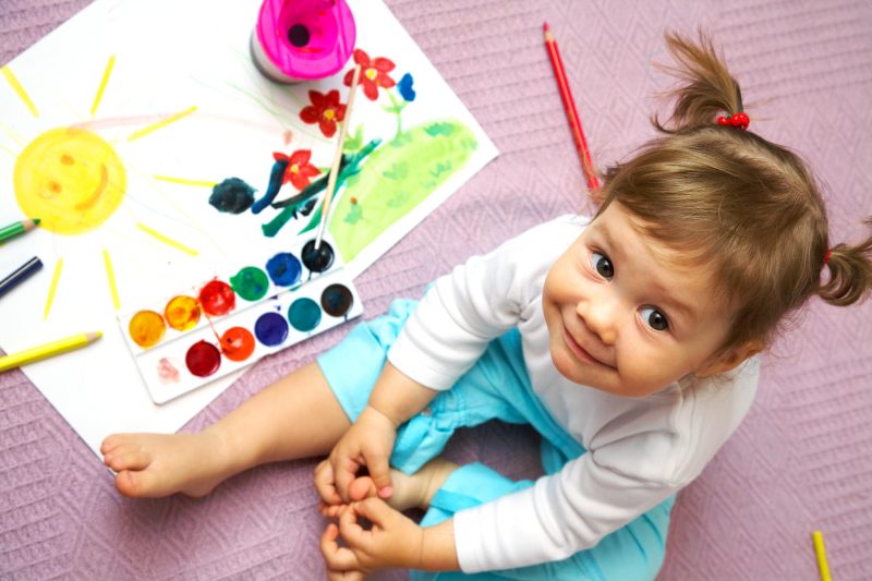 کودک دو ساله در حال بازی با رنگ ها