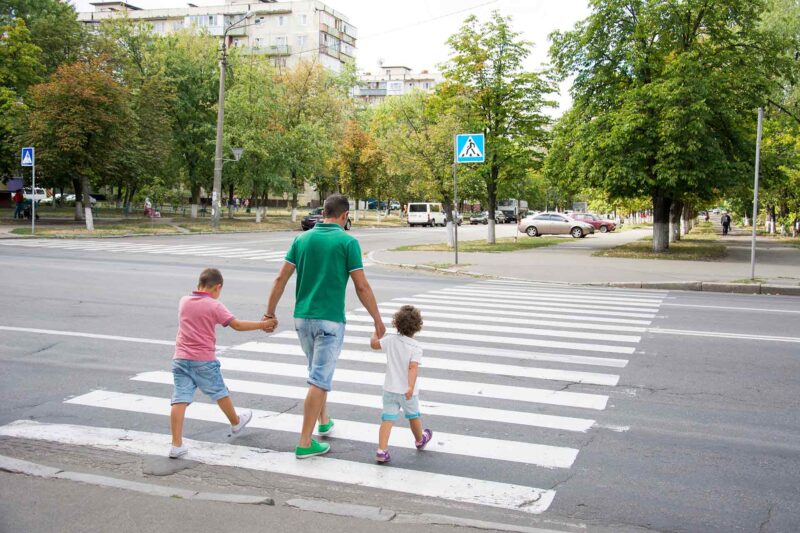 پدر و کودکان در حال عبور از خط عابر پیاده
